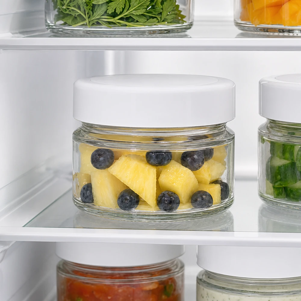 80ml Rundglas mit BasicSeal Deckel weiß deep UNiTWIST 80ml Rundglas im Kühlschrank mit Ananas und Blaubeeren zeigt optimale Frischhalte-Eigenschaften des BasicSeal Deckels