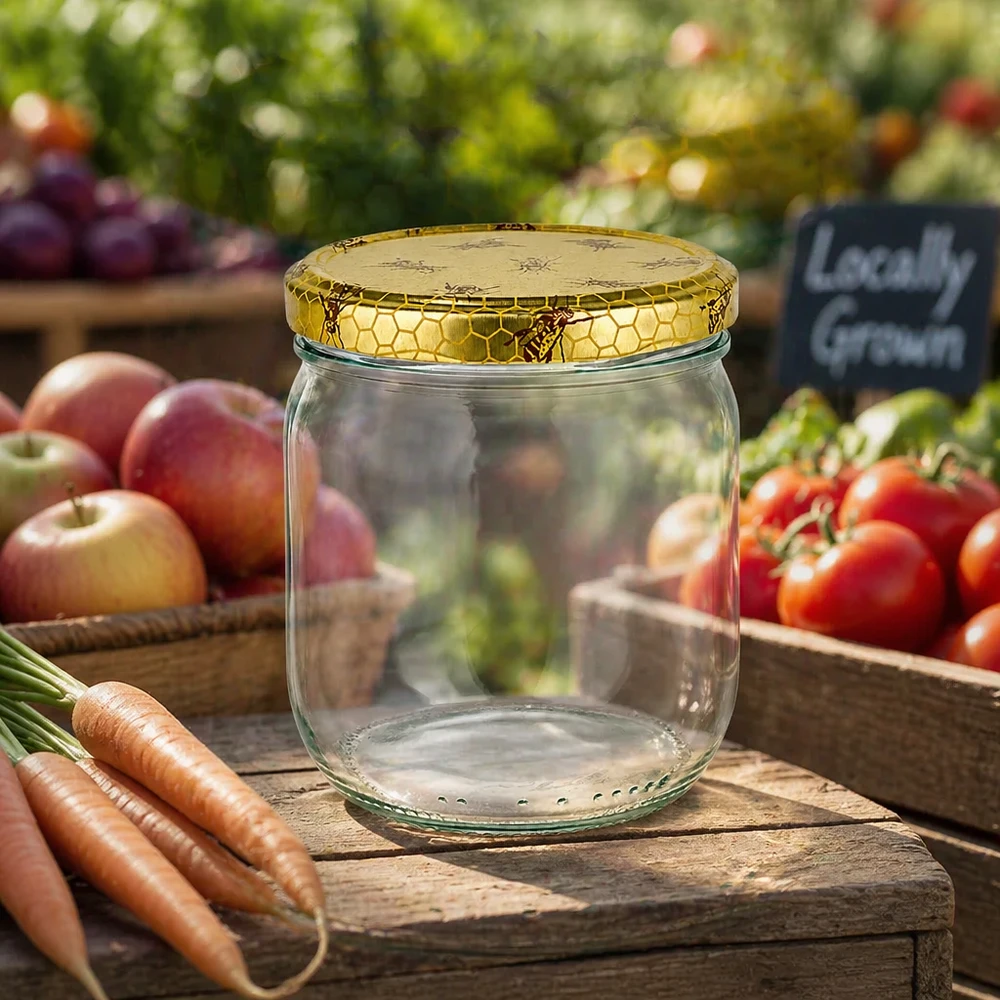 Leeres 500g Honigglas mit Bienenwaben-Deckel auf Holzbrett zwischen frischem Gemüse vom Bauernmarkt