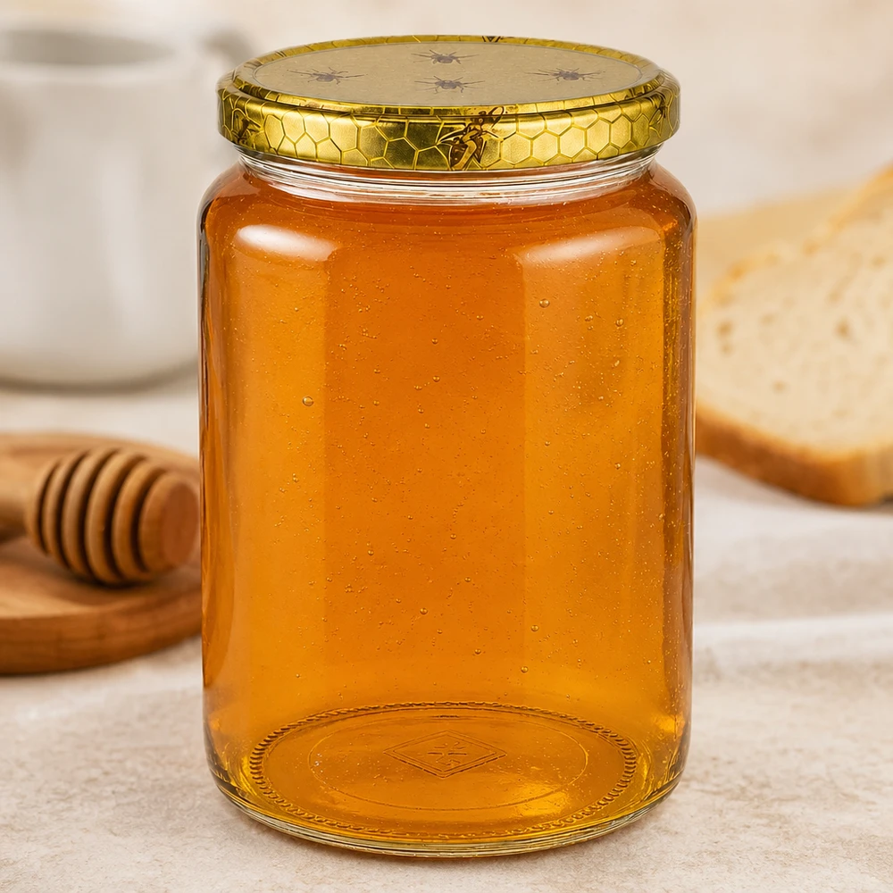 1000g Honigglas mit Bienenwabe Deckel BasicSeal UNiTWIST Großes 1000g Honigglas mit Prägung am Boden neben Honigstab und Brot auf Holzbrett Küchenszene Imkereibedarf