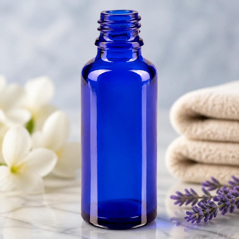 Tropfflasche 30ml DIN 18 BLAUGLAS ApoGlas 30ml Flasche in Blau umgeben von Spa-Accessoires Lavendel und Jasminblüten