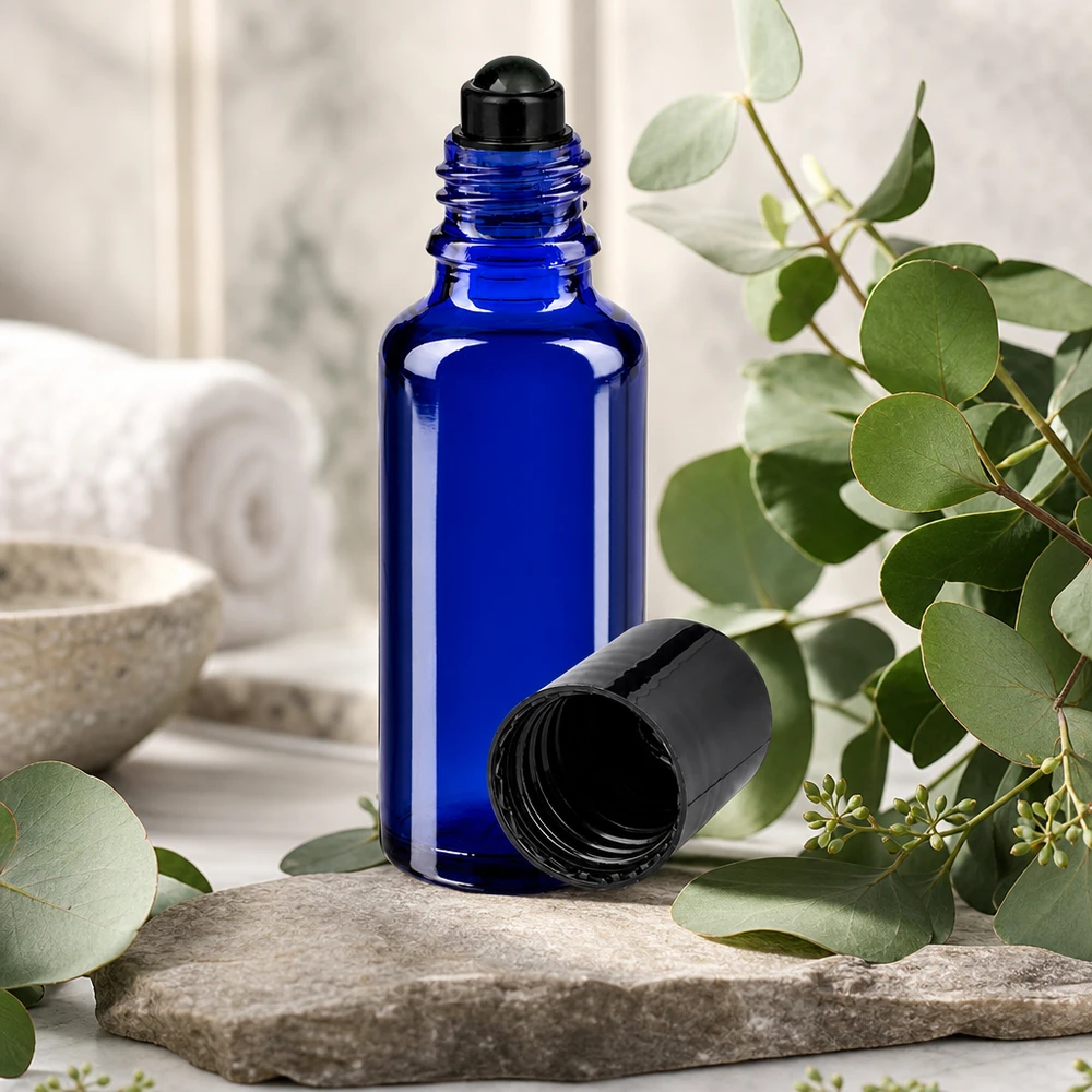 Apothekenflasche blau 30ml Roll-On Verschluss schwarz 30ml Roll-On Gebinde aus blauem Borosilikatglas mit schwarzem Schraubverschluss auf Steinuntergrund