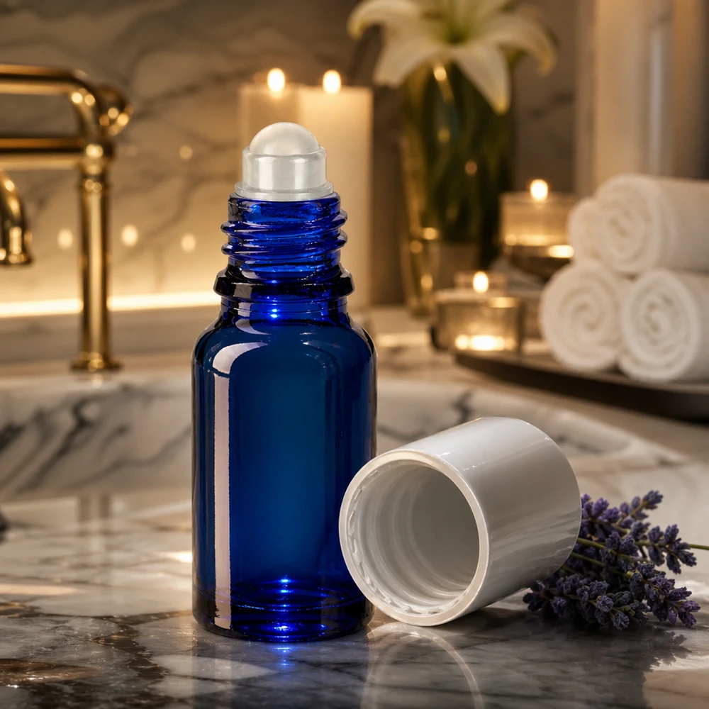 Apothekenflasche blau 10ml Roll-On Verschluss weiß Kobaltblaue 10ml Rollerflasche mit abgenommenem weißen Deckel vor Kerzen und Handtüchern