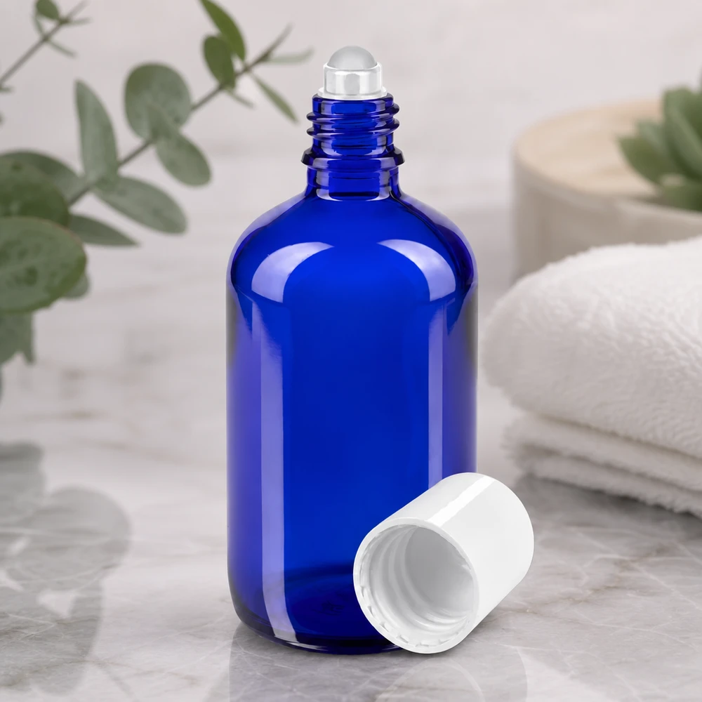 Apothekenflasche blau 100ml Roll-On Verschluss weiß Hochwertige kobaltblaue 100ml Roll-On Flasche aus Apothekerglas vor natürlichem Eukalyptus Hintergrund