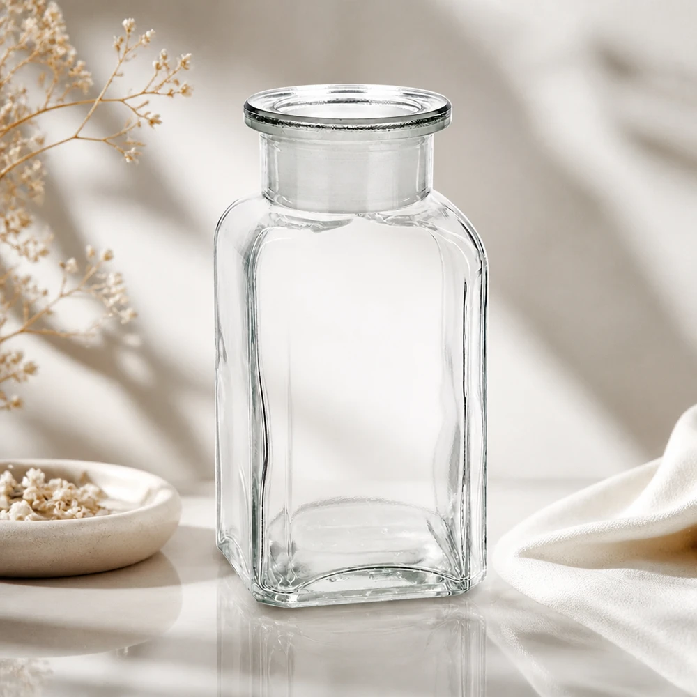 Klare 100ml Vierkantflasche mit Glasverschluss luftiger Hintergrund mit getrockneten Wiesenblumen