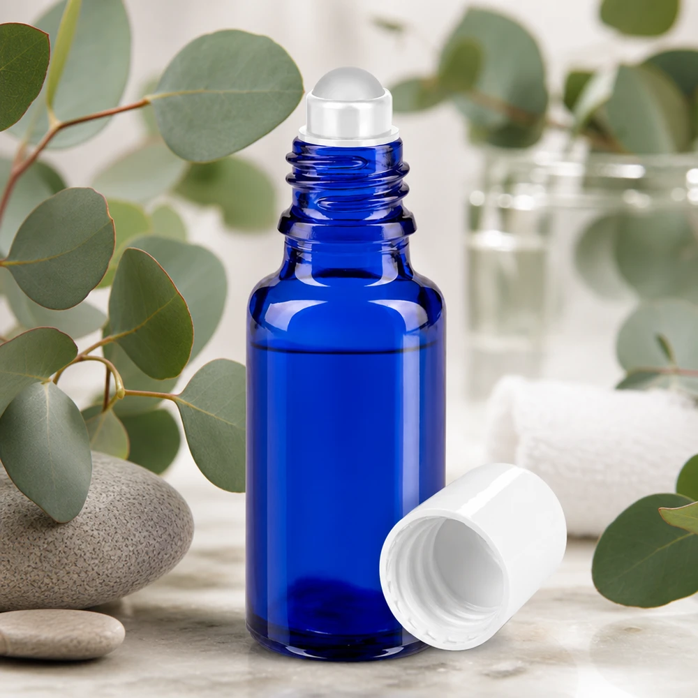 Roll-On Flasche 20ml kobaltblau mit weißem Deckel umgeben von Eukalyptus und Spa-Elementen