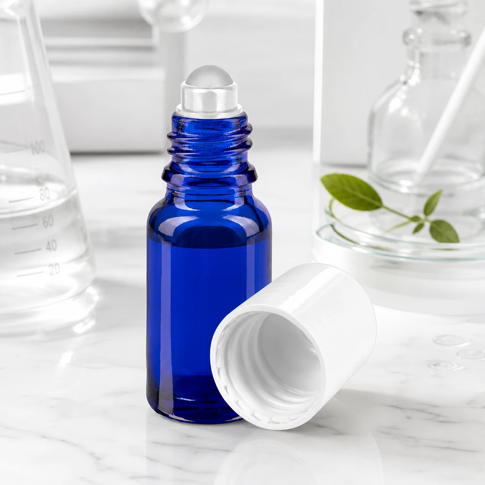 Apothekenflasche blau 10ml Roll-On Verschluss weiß Kleine blaue Roll-On Flasche 10ml mit Rollkugel neben grünen Pflanzenblättern und Messbecher