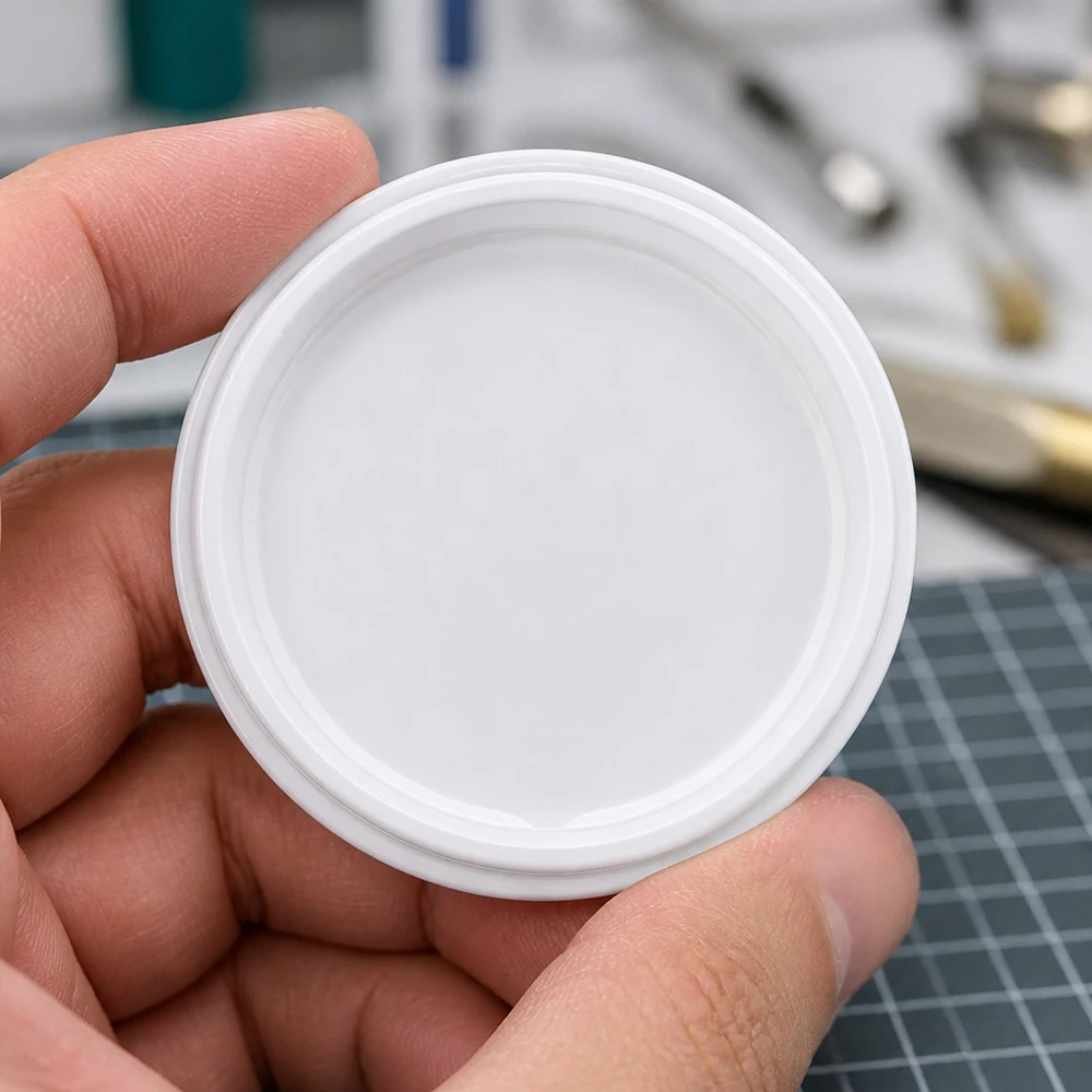 Weisser TO63 Twist-Off-Deckel BioSeal BPA-NI unitemp zwischen Daumen und Fingern gehalten