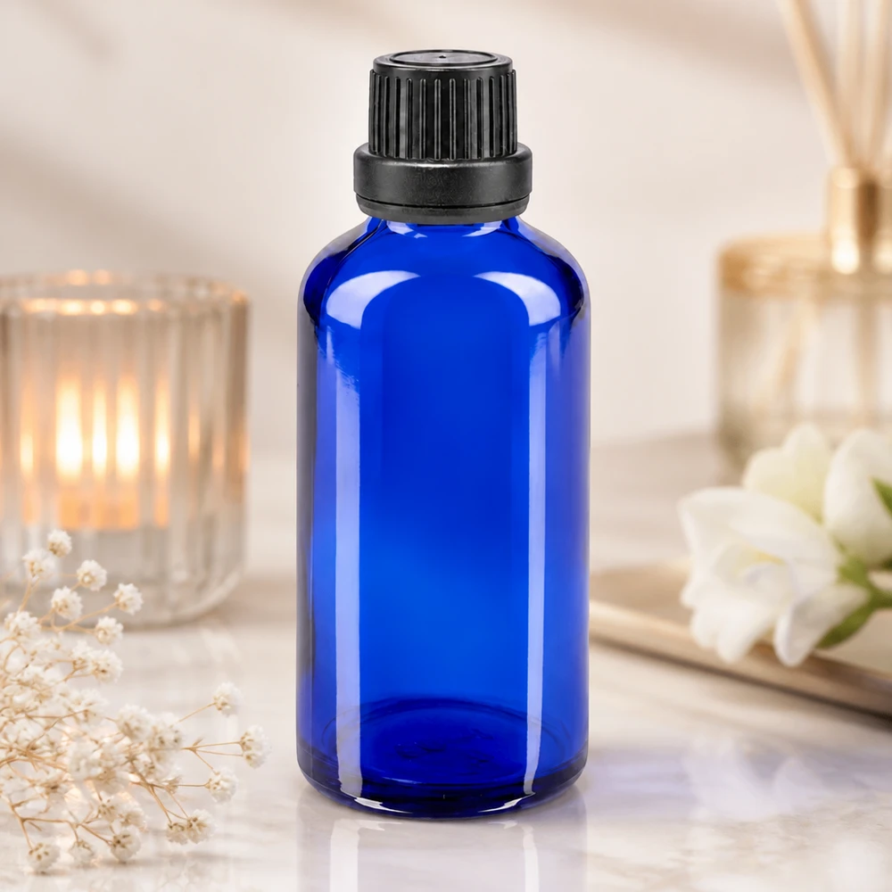 Zylindrische blaue 50ml Tropfflasche aus Apothekenglas mit schwarzem OV-Deckel vor Raumduftdiffuser
