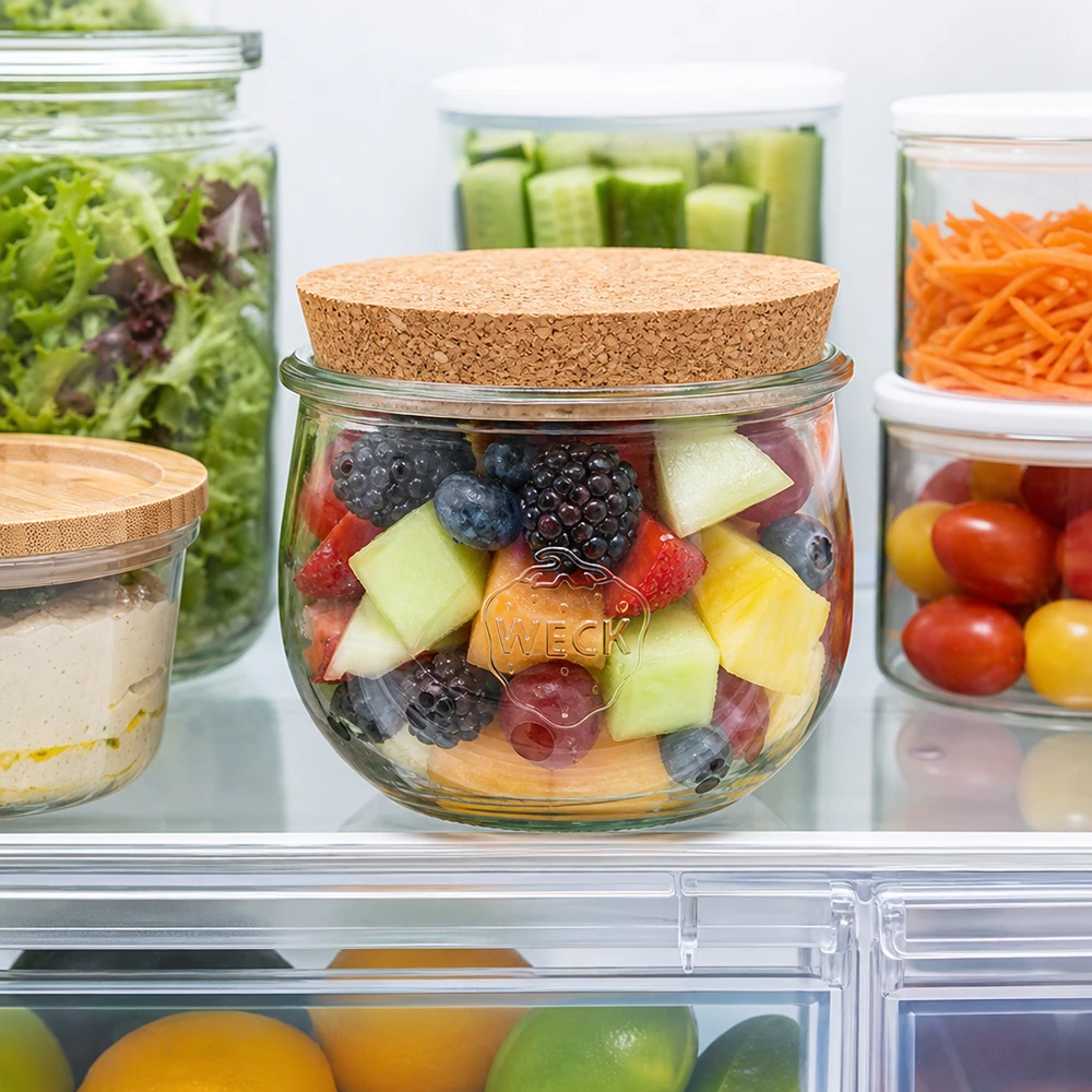 WECK Tulpenglas 580ml mit Korkdeckel im Kühlschrank gefüllt mit Obstsalat neben anderen Vorratsgläsern mit Gemüse