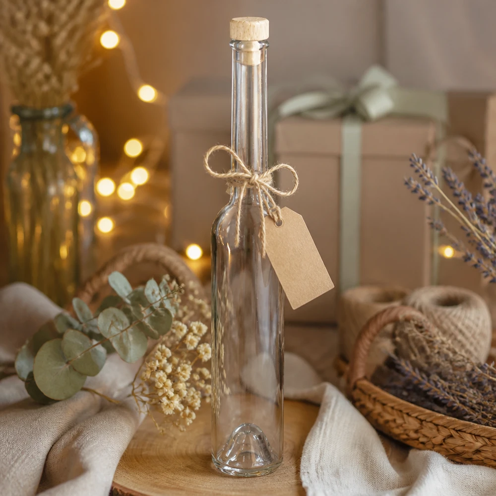 Glasflasche Hugo 100ml mit Korken und Geschenkanhänger in natürlicher Deko-Szene mit Lavendel und Lichterkette