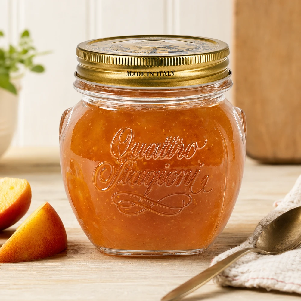 300ml Rundglas "Quattro Stagioni" mit Deckel 300ml Quattro Stagioni Rundglas mit goldenem Deckel gefüllt mit Marmelade auf Holztisch neben Orangenscheiben