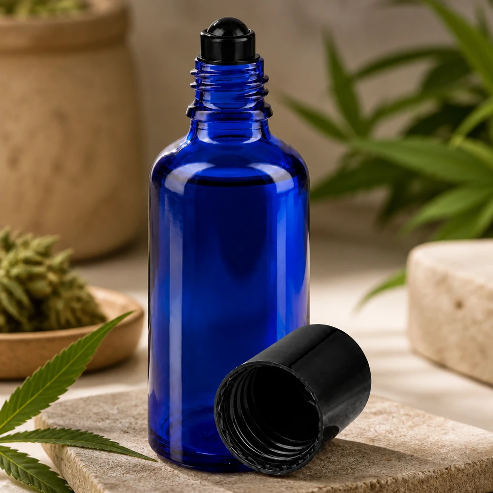 Apothekenflasche blau 50ml Roll-On Verschluss schwarz Blaue 50ml Rollerflasche aus Apothekerglas mit schwarzem Kugelaufsatz auf Naturstein Untergrund