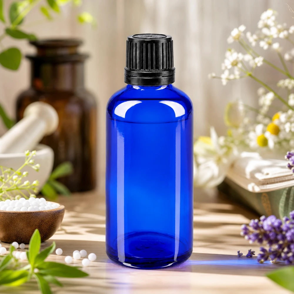 Apothekenflasche blau 50ml Schraubverschluss schwarz Giessring Originalitätsverschluss 50ml kobaltblaue Apothekerflasche mit schwarzem 8mm Verschluss neben Bernsteinglas und Heilpflanzen