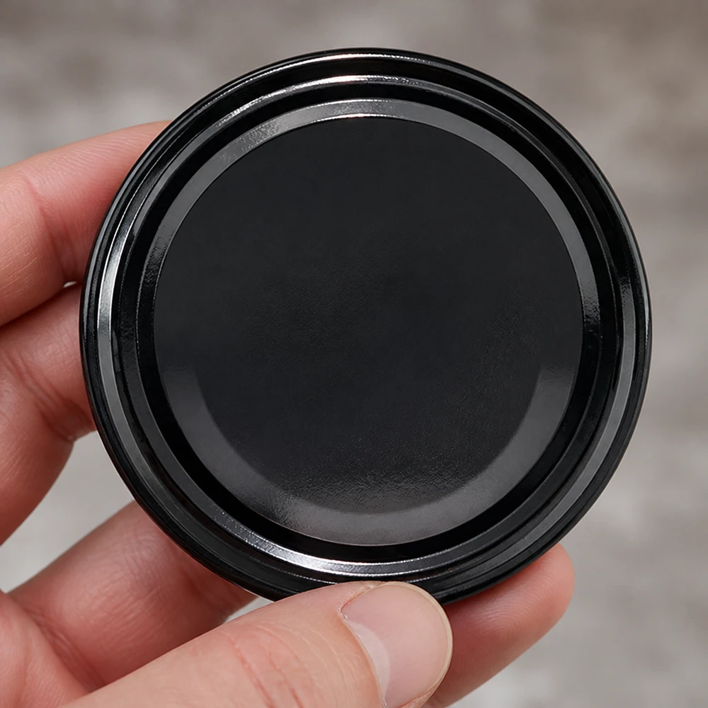 Hand hält UNiTWIST TO82 Schraubdeckel schwarz 82mm Twist-Off Verschluss Frontansicht Nahaufnahme