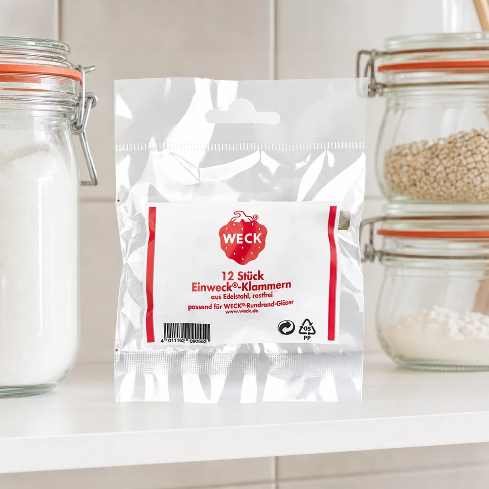 WECK Klammern Produktverpackung in Küche zwischen Vorratsgläsern mit Getreide Mehl auf weißer Arbeitsplatte Küchenambien