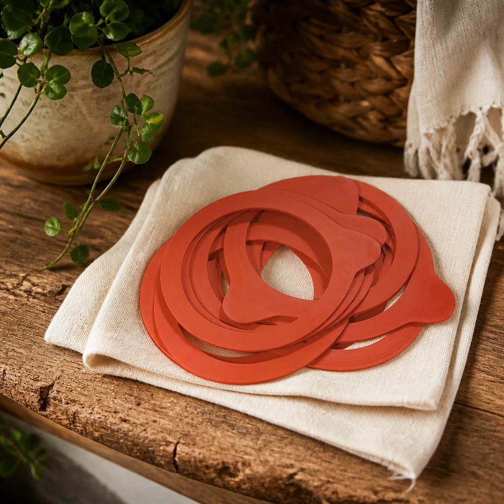 Einkochring Naturgummi RR60 Einkochringe RR60 Naturgummi orange auf Leinentuch rustikaler Holztisch mit Pflanze natürliche Küchenatmosphäre