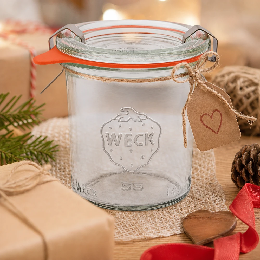 WECK Sturzglas 140ml RR60 als Geschenkidee dekoriert mit Herzanhänger und Juteschnur auf Holztisch mit Tannenzapfen