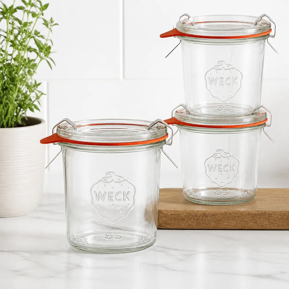 140ml Sturzglas komplett WECK RR60 Drei WECK Sturzgläser 140ml RR60 gestapelt auf Holzbrett in moderner Küche mit Grünpflanze im Hintergrund