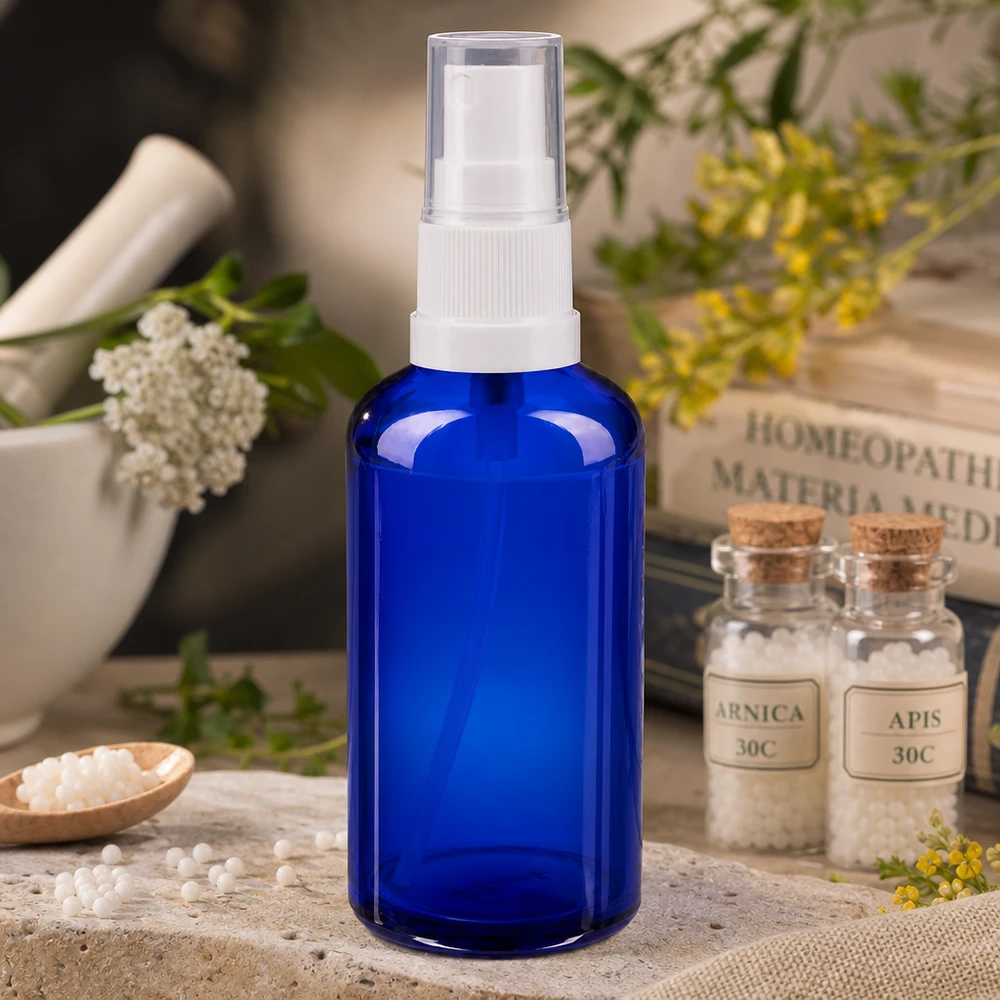 Apothekenflasche blau 50ml Sprayaufsatz weiß Blaues 50ml Apothekerglas mit weißem Sprühkopf neben Mörser und Heilpflanzen